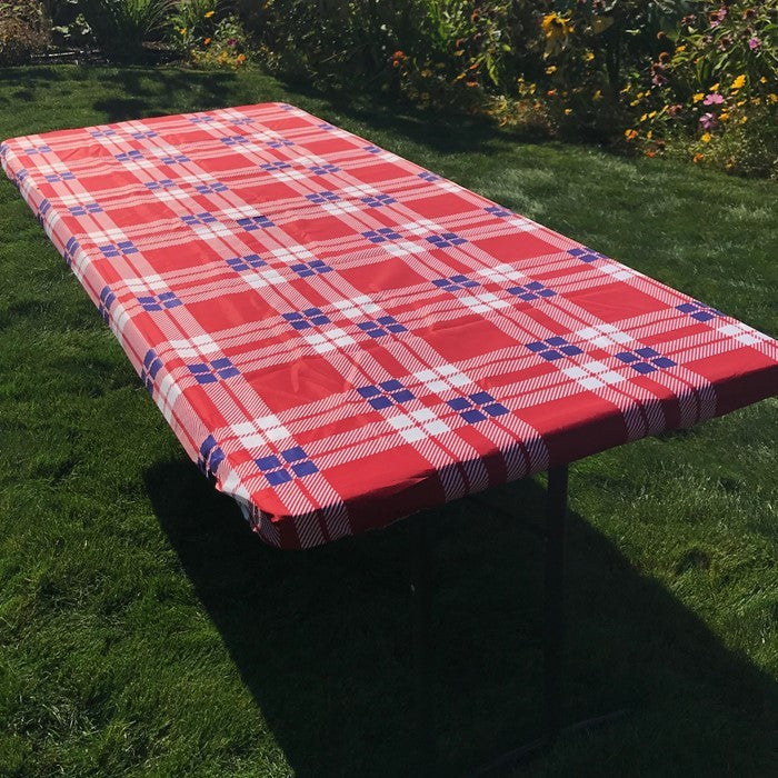 Plaid 6' Tablecloth spread over a picnic table in a sunny outdoor setting, secured with deep pockets, enhancing the cheerful atmosphere.