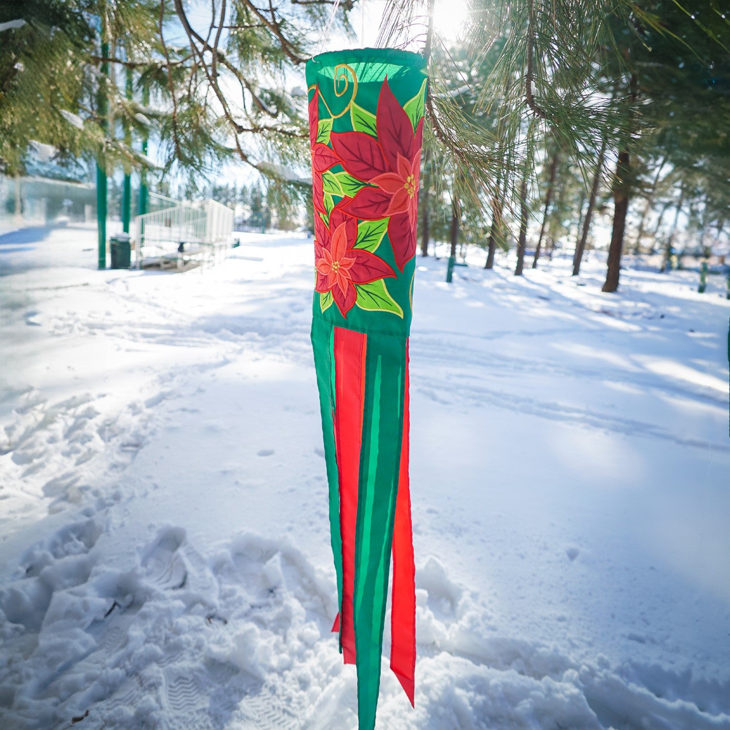 Poinsettia 40" Windsock displaying vibrant red flowers and colorful tails, fluttering in the wind, perfect for winter holiday outdoor decoration.