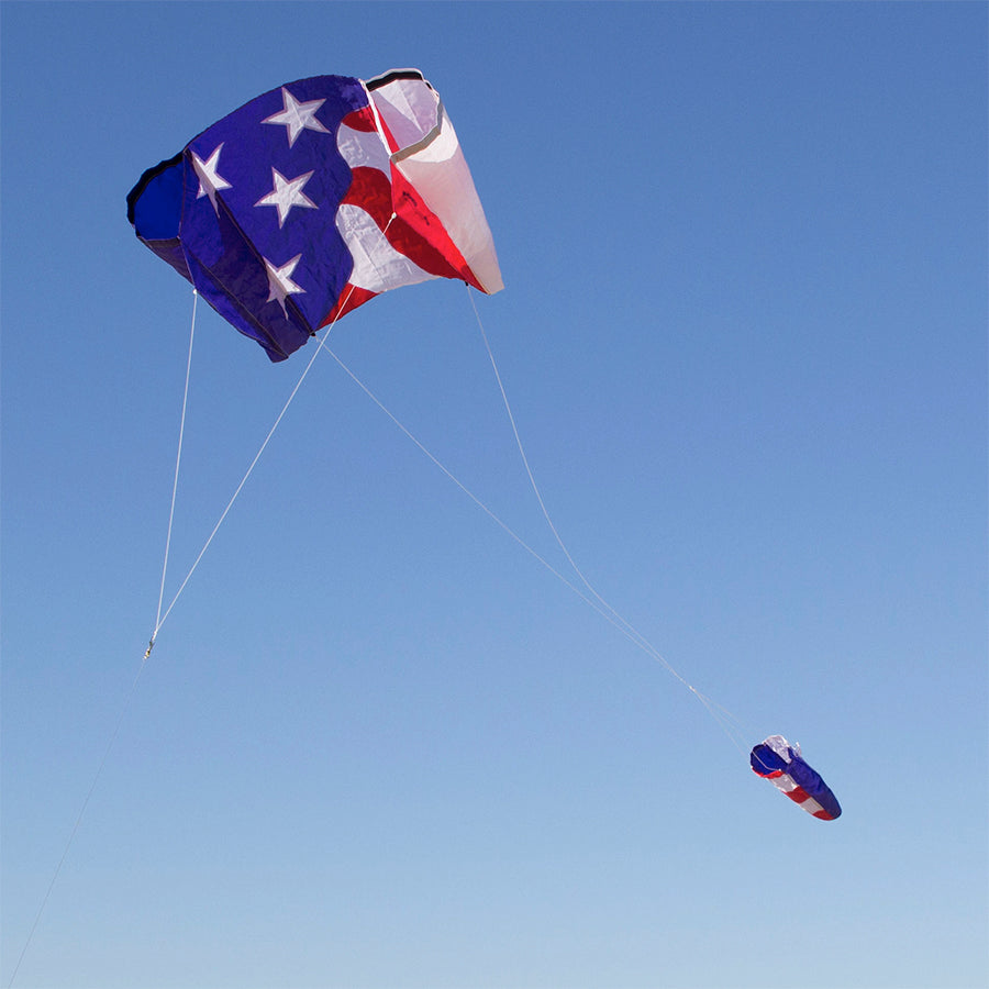 Power Sled 10 kite measuring 36 x 27 inches in a vibrant red, white, and blue design soaring against a clear blue sky.