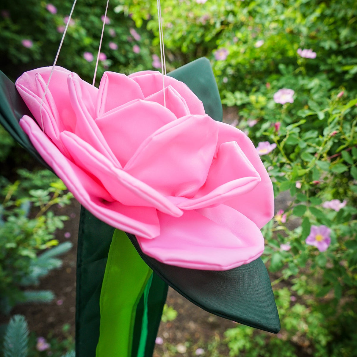 Pretty as a Rose Floral Windtail featuring 3D rose blossoms and color-coordinated tails hanging gracefully in an outdoor setting.