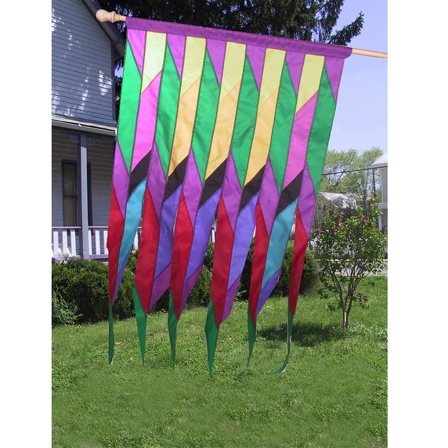 Progressive Banner - Cellon Passion with vibrant Native American-inspired designs displayed on an outdoor flag pole in a garden setting.