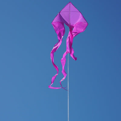 Purple 77' Wave Delta Kite soaring in a bright blue sky with long flowing tails dancing behind it, designed for easy flying.