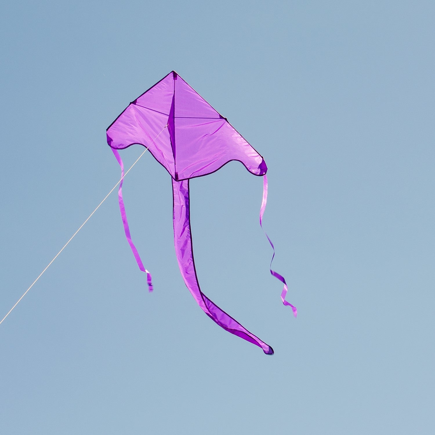 Purple Colorfly 43\" Fly-Hi Kite soaring in the sky, showcasing its solid color design and delta shape, ideal for beginner kite flyers.