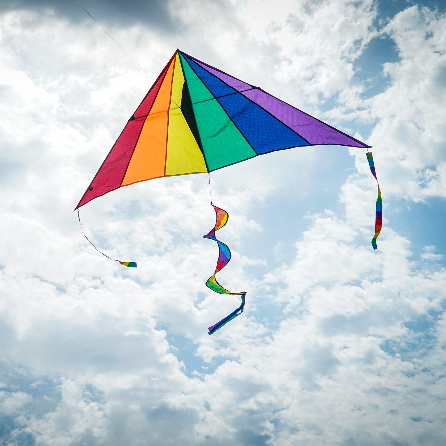 Rainbow 7' Delta Combo Kite with colorful twister tail and streamers in flight, displaying vibrant rainbow colors against a blue sky.