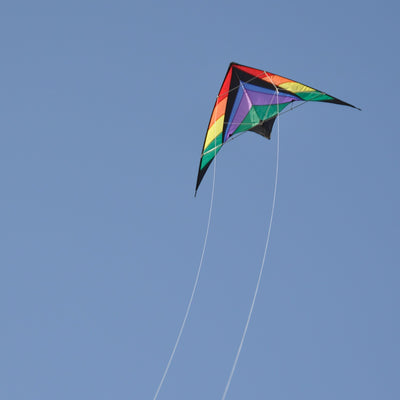Rainbow Breeze 68" Sport Kite in rainbow color soaring high in a clear blue sky, showcasing its vibrant design and dual control lines.