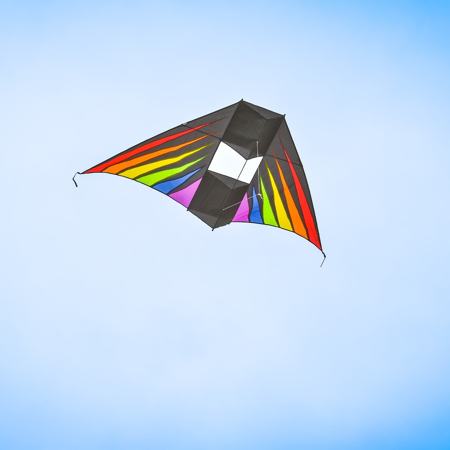 Rainbow Burst 6' Conyne Delta Kite featuring vibrant colors displayed in an outdoor setting with blue skies and fluffy clouds, ideal for family fun.