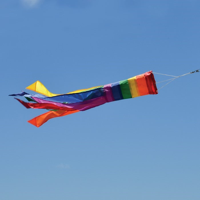 Rainbow Column 24" Windsock featuring vibrant colors and six coordinated tails, displayed outdoors in a garden setting.