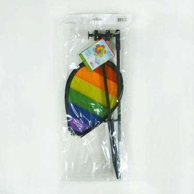 Colorful Rainbow Dazee Spinner featuring swirled petal design displayed in an outdoor garden, captivating attention as it spins in the breeze.