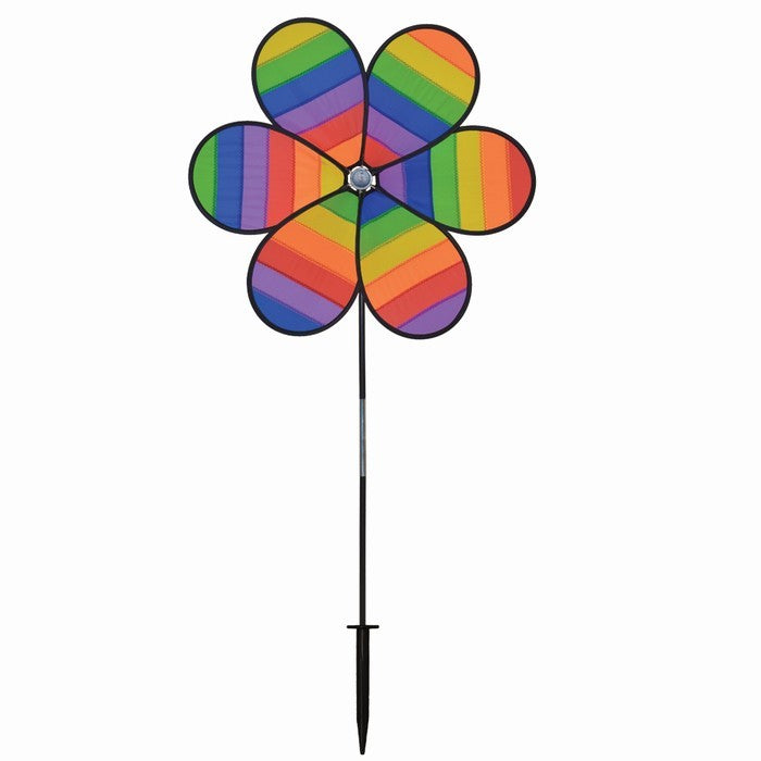 Colorful Rainbow Dazee Spinner featuring swirled petal design displayed in an outdoor garden, captivating attention as it spins in the breeze.