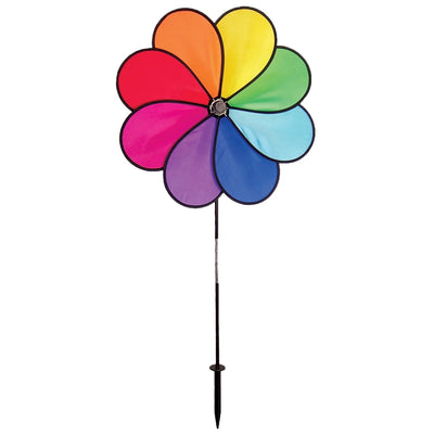 Rainbow Dazy Petal Spinner features eight colorful petals arranged in a flower design, spinning in the breeze atop a sturdy pole in a garden setting.