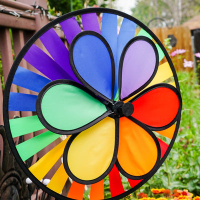 Rainbow Dazy Wheel garden spinner featuring a colorful design with a 12-inch petal top and a 15-inch spinner wheel, displayed outdoors.