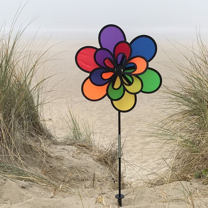 15-inch Rainbow Double Windee Wheelz garden spinner displaying vibrant colors in rotation, supported by a sturdy fiberglass pole and stake.