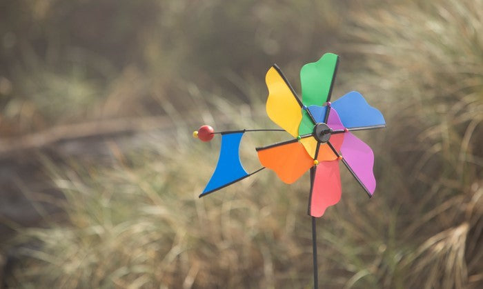 Rainbow Flower Windmill Ground Spinner featuring a colorful flower design, crafted from durable materials, spinning elegantly in the garden.