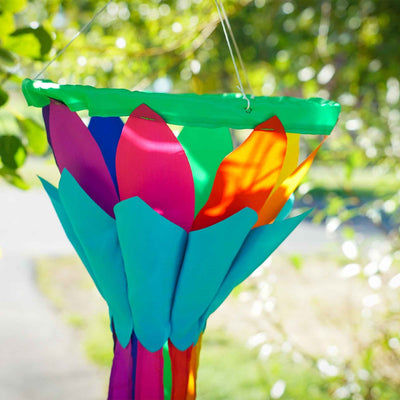 Rainbow 38'' Lotus Flower Windsock with colorful petals and flowing tails, gently swaying in the breeze, hanging in a garden setting.
