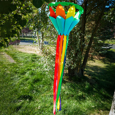 Rainbow 38'' Lotus Flower Windsock with colorful petals and flowing tails, gently swaying in the breeze, hanging in a garden setting.