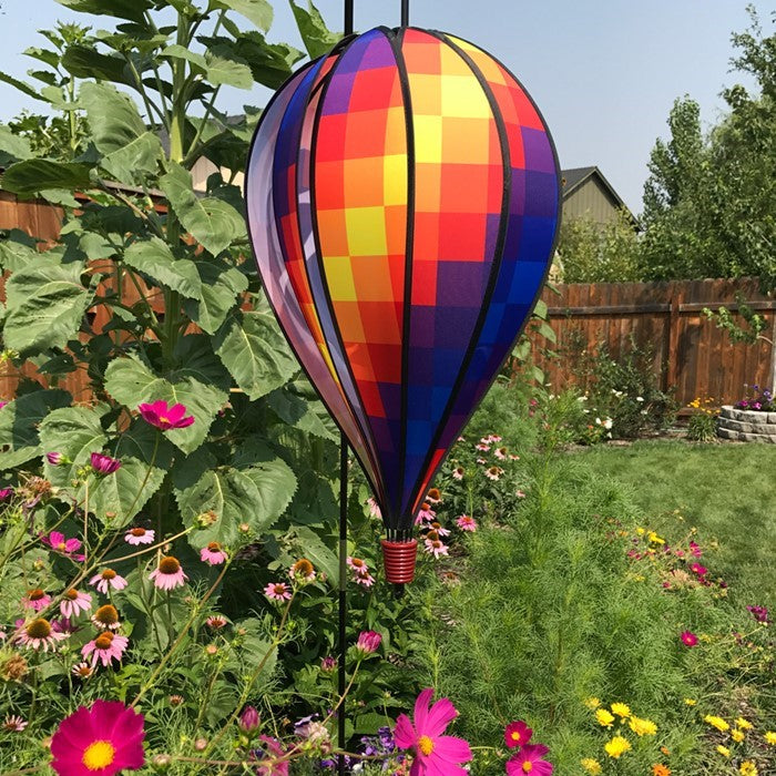 Rainbow Pixel 10-Panel Hot Air Balloon showcased in a garden, spinning in the breeze, showcasing its vibrant pixelated colors.
