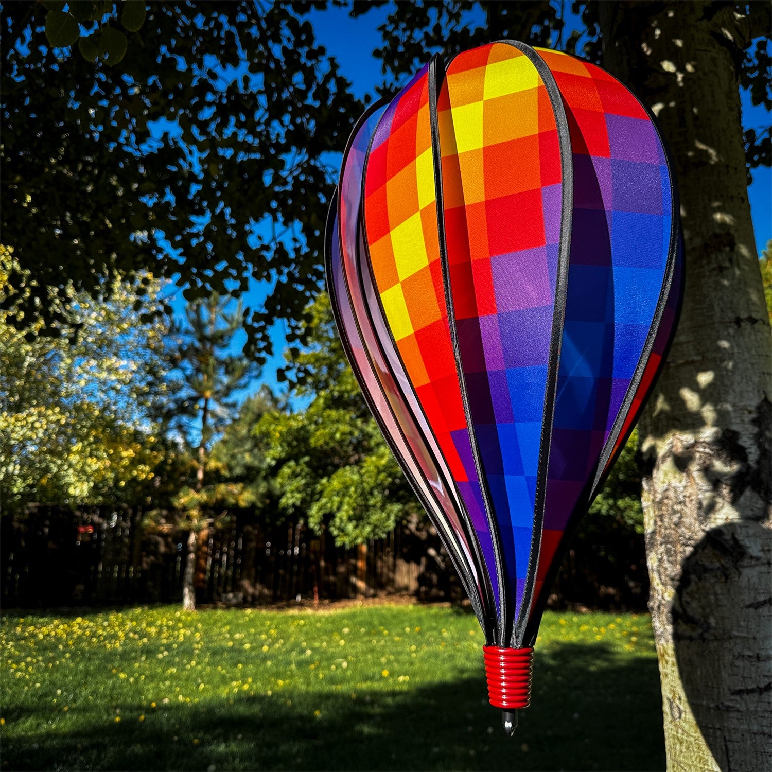 Rainbow Pixel 10-Panel Hot Air Balloon showcased in a garden, spinning in the breeze, showcasing its vibrant pixelated colors.