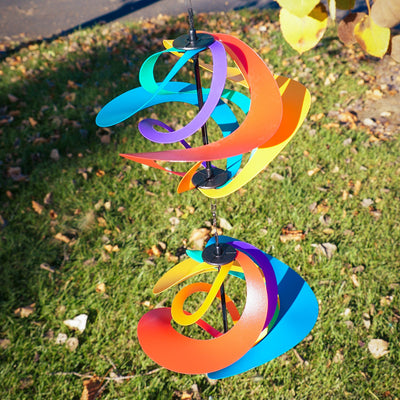 Colorful Rainbow Poly Vortex Double Spinner with interconnected spirals hanging in a garden, catching the breeze beautifully.