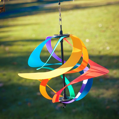 Colorful Rainbow Poly Vortex Spinner with six interconnected spirals hanging in a garden, spinning gently in the breeze.