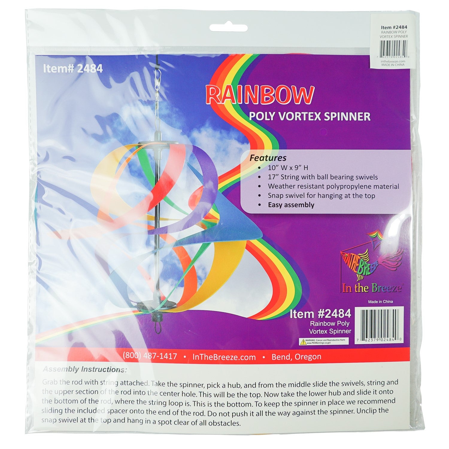 Colorful Rainbow Poly Vortex Spinner with six interconnected spirals hanging in a garden, spinning gently in the breeze.