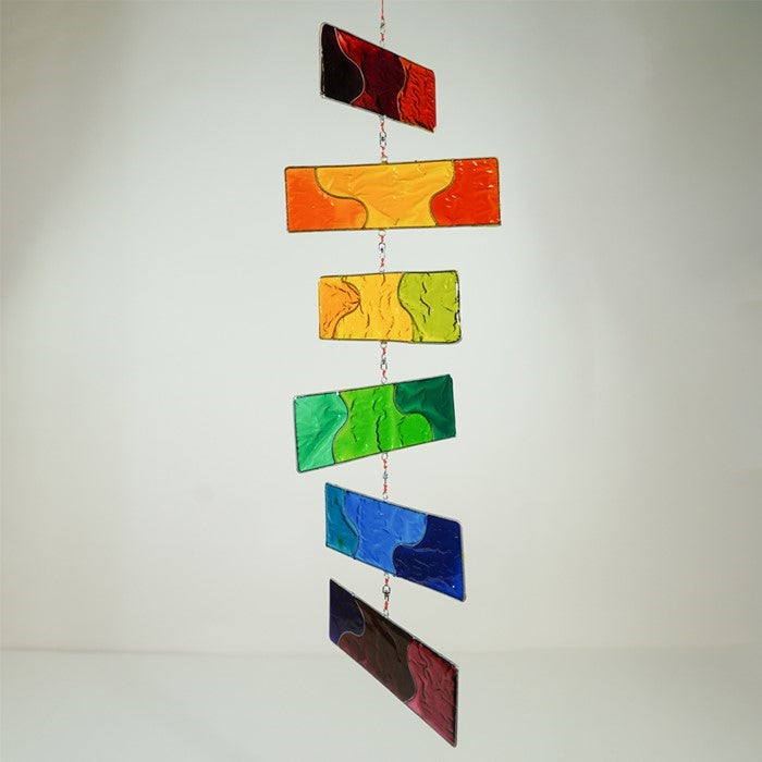 Rainbow Resin Mobile with six colorful translucent blocks hanging outdoors, catching sunlight and swaying gently in the breeze.