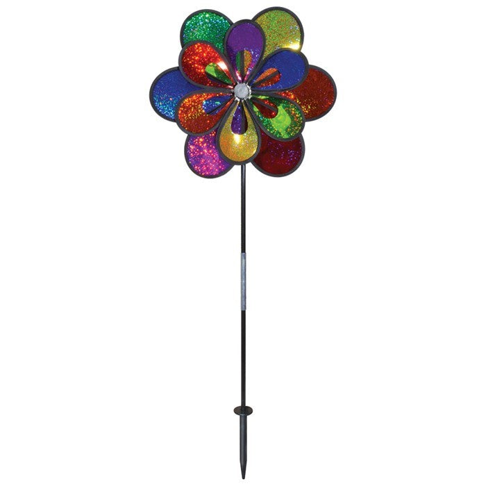 Rainbow Sparkle Windee Wheelz and Flower Spinner featuring double Mylar wheels adorned with colorful petals, spinning in a gentle breeze in a garden setting.