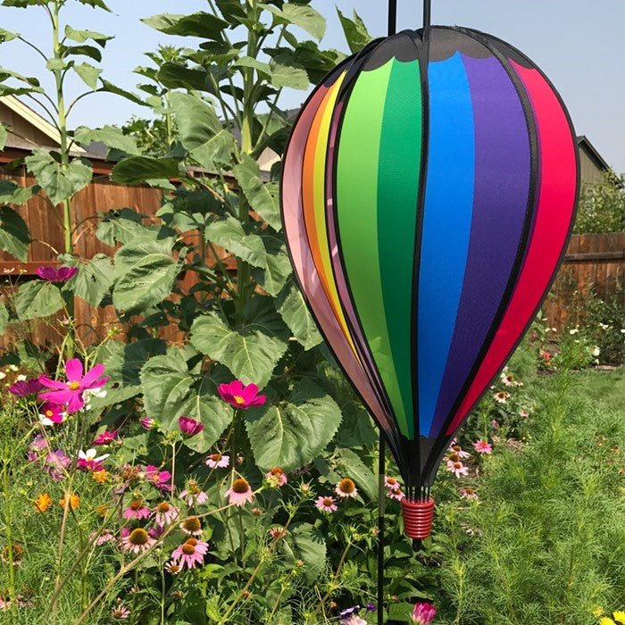 Rainbow Spectrum 10-Panel Hot Air Balloon spinner featuring colorful panels gently spinning in a garden setting, capturing the joy of outdoor decor.