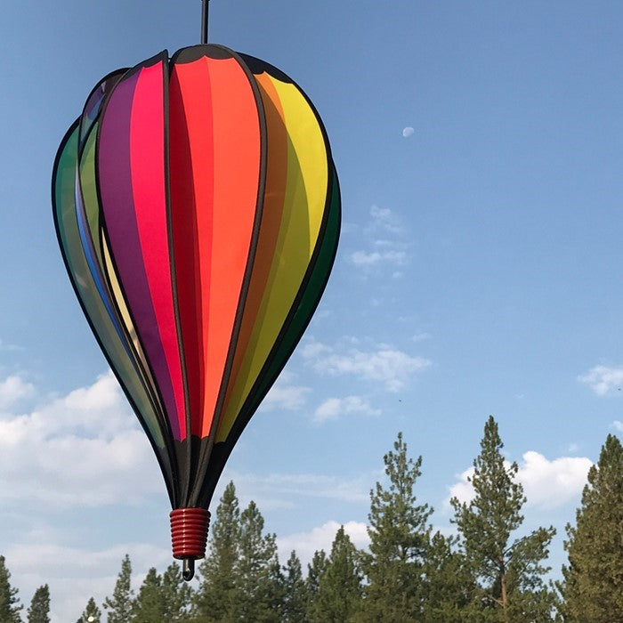 Rainbow Spectrum 10-Panel Hot Air Balloon spinner featuring colorful panels gently spinning in a garden setting, capturing the joy of outdoor decor.