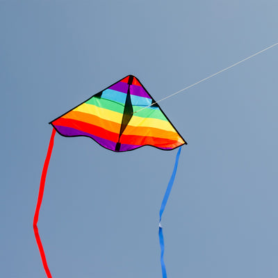 Colorful Rainbow Stripe 30-inch Delta Kite, featuring durable ripstop fabric and stable design, displayed soaring in a bright blue sky with playful tails fluttering below.