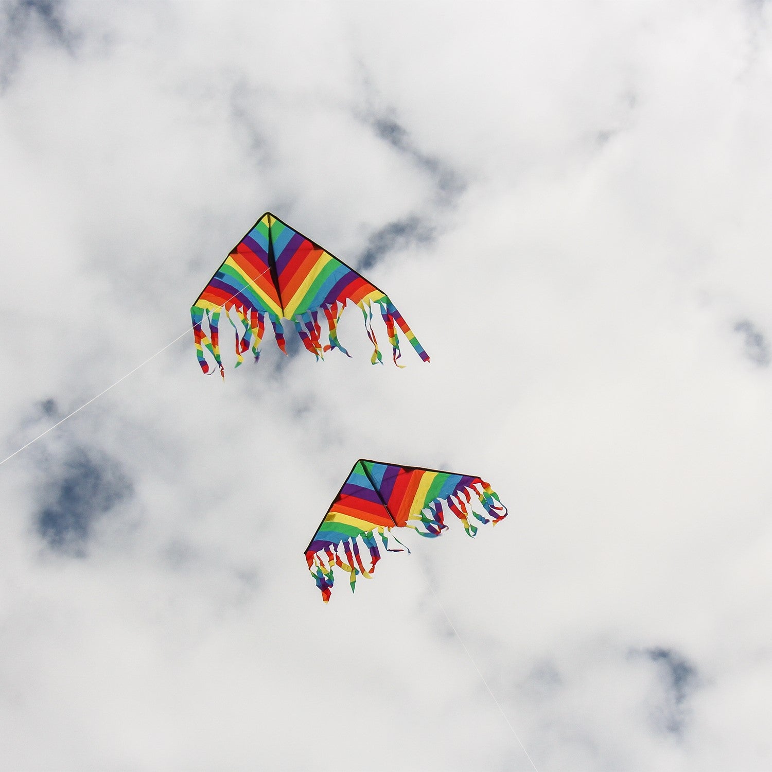 Rainbow Stripe 43" Flutterfly Delta kite soaring in the sky with colorful fluttering tails, perfect for outdoor fun and family activities.