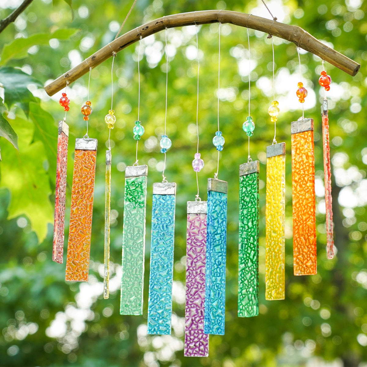 Rainbow Textured Glass Mobile Wind Chime with colorful glass panels and wooden hanging bar, displayed outdoors catching sunlight.