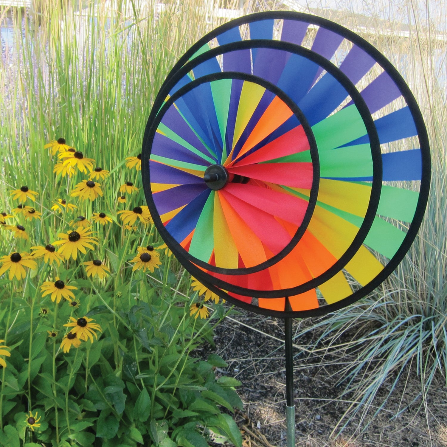 Rainbow Triple Wheel Spinner made with colorful wheels and sturdy fiberglass frame, beautifully spinning outdoors for garden charm and fun.