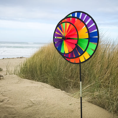Rainbow Triple Wheel Spinner made with colorful wheels and sturdy fiberglass frame, beautifully spinning outdoors for garden charm and fun.