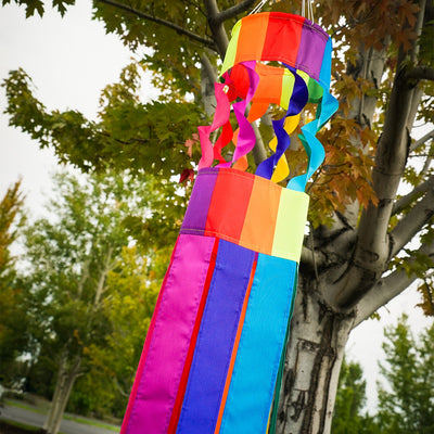 Visualize the Rainbow Twistair Windsock with its vibrant, swirling colors and eight flaring tails fluttering gracefully in the breeze, creating a joyful display.