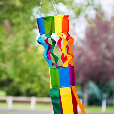 Visualize the Rainbow Twistair Windsock with its vibrant, swirling colors and eight flaring tails fluttering gracefully in the breeze, creating a joyful display.