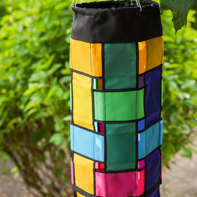 Colorful Rainbow Weave 40" Windsock with black edging and fluttering tails displayed outdoors, showcasing vivid colors against the backdrop.