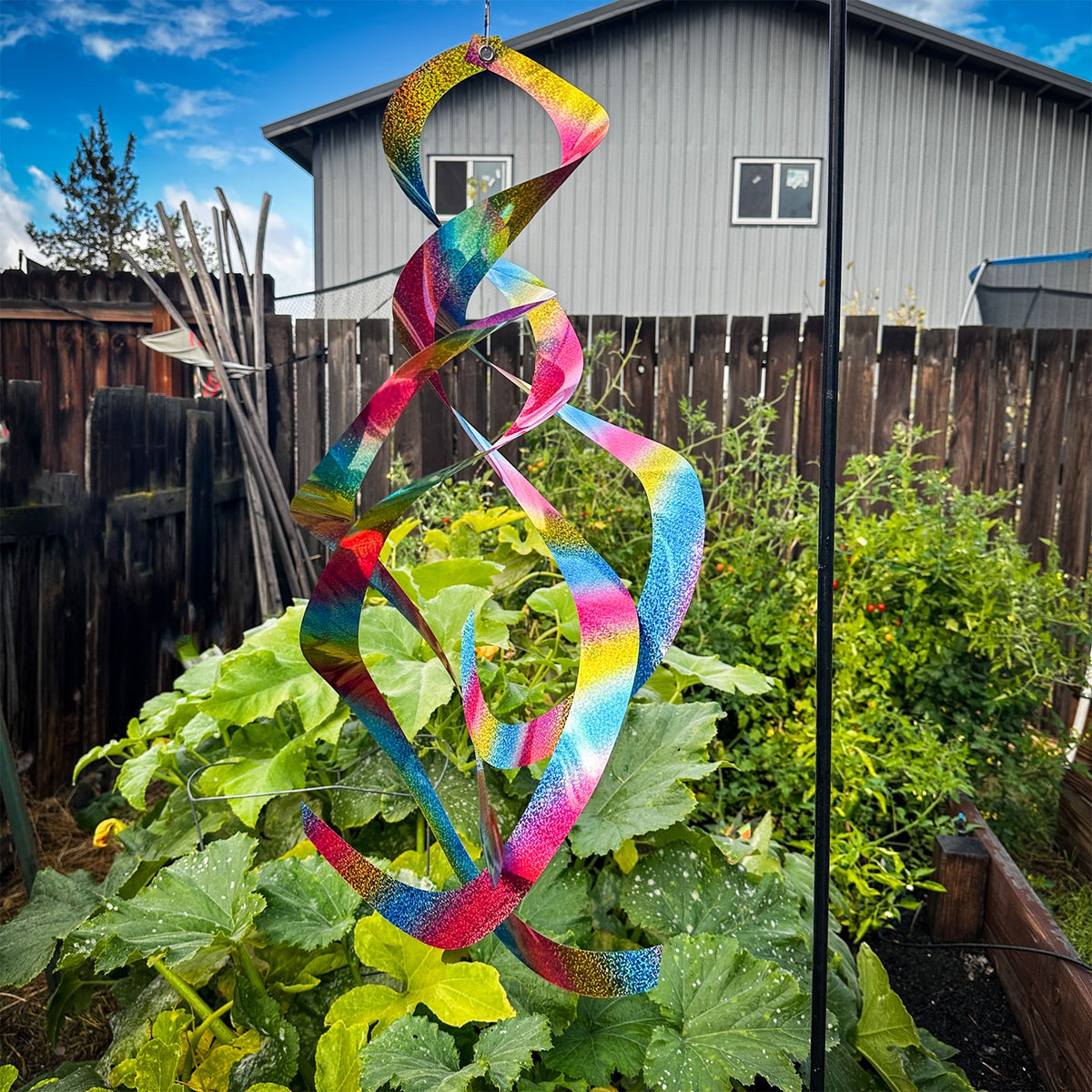 The Rainbow Whirl Mylar Spin Quartet is a stunning hanging decor featuring vibrant mylar curls that shimmer in the sunlight, ideal for outdoor festivities and gardens.