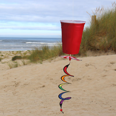 Red Cup 5 O'Clock Spinner features a colorful spinning design resembling a classic red party cup, hanging outdoors in a breezy garden setting.