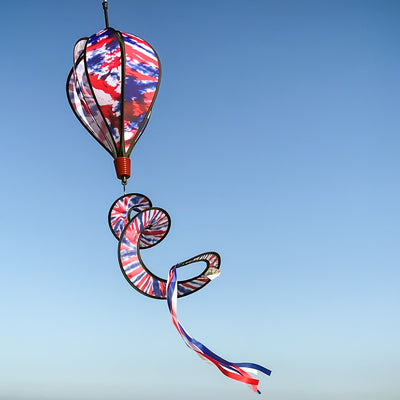 Red, White and Blue Tie Dye 6-Panel Hot Air Balloon spinner in an outdoor setting, showcasing its vibrant colors and delightful movement in the air.