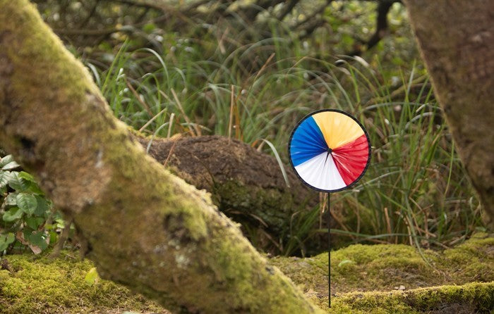 Red, White, Blue and Yellow Spinning Runner displayed in a garden, showcasing vibrant colors and dynamic spinning action.