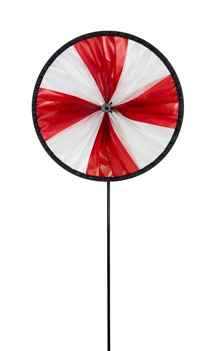 Red and White Spinning Runner with an 8-inch wheel spinning joyfully in a lush garden setting, showcasing its vibrant colors.