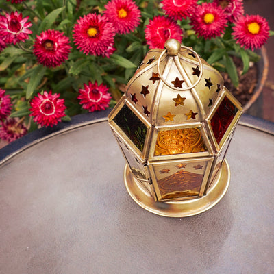 Red, Yellow & Green Hex Glass Tealight Lantern showcasing intricate patterned glass in a hexagonal shape, hanging outdoors creating ambient light.
