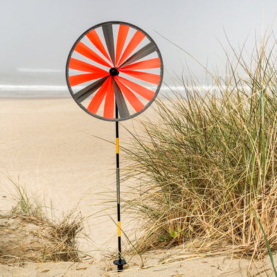 Retroreflective Orange 12' Spinner Wheel with glowing neon color displayed in a driveway setting, showcasing its reflective properties and weather-resistant design.