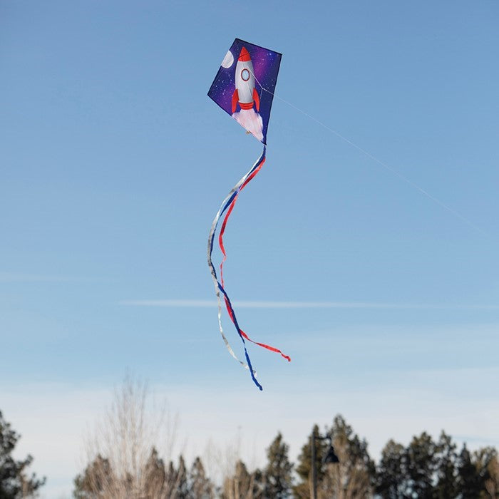 Rocket 30-inch Diamond Kite featuring a colorful rocket ship design with three attached tails, flying high against a blue sky.