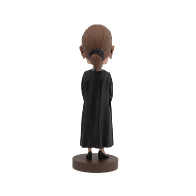 Ruth Bader Ginsburg bobblehead featuring her signature black robe, glasses, and earrings, displayed on a shelf as a tribute to her legacy.