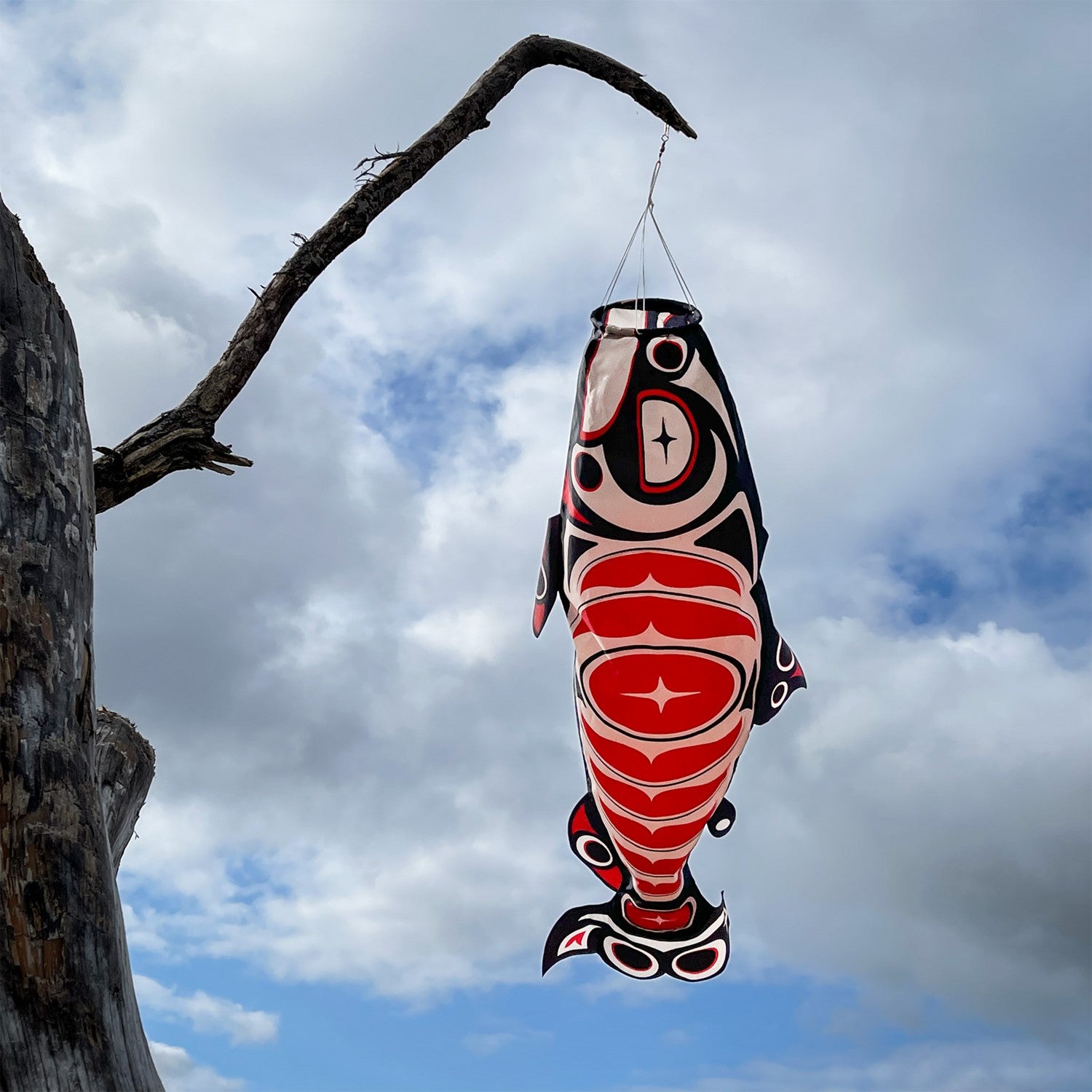 Salmon Totem 48' Fish Windsock featuring vibrant printed patterns hanging outdoors, gently fluttering in the breeze.