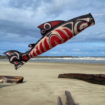 Salmon Totem 48' Fish Windsock featuring vibrant printed patterns hanging outdoors, gently fluttering in the breeze.