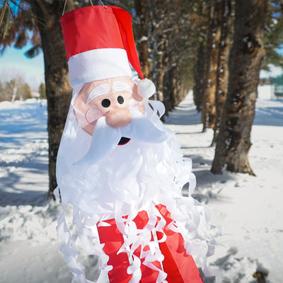 Santa 3D Windsock featuring a cheerful Santa face with curly beard and textured hat, hanging decoratively outdoors in a festive setting.