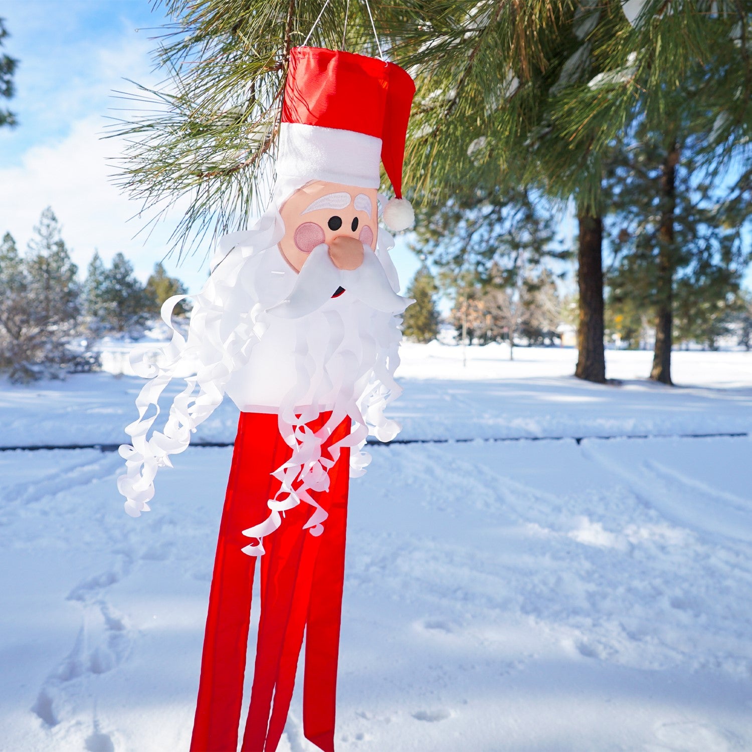 Santa 3D Windsock featuring a cheerful Santa face with curly beard and textured hat, hanging decoratively outdoors in a festive setting.