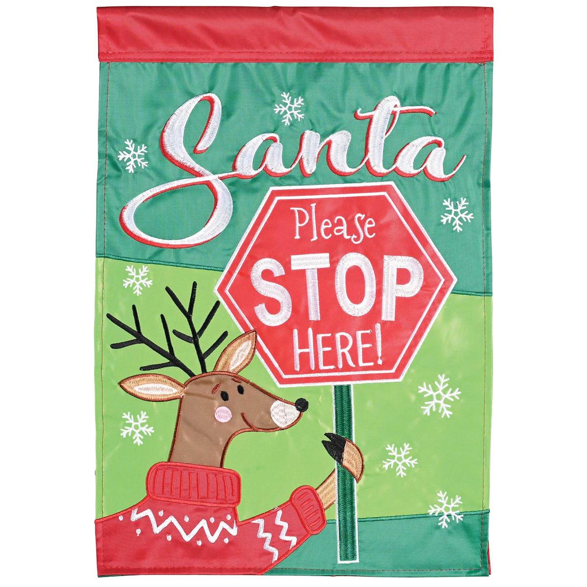 Vibrant Santa Please Stop Here! banner flag measuring 29x42 inches featuring festive lettering, displayed outdoors in a winter setting.
